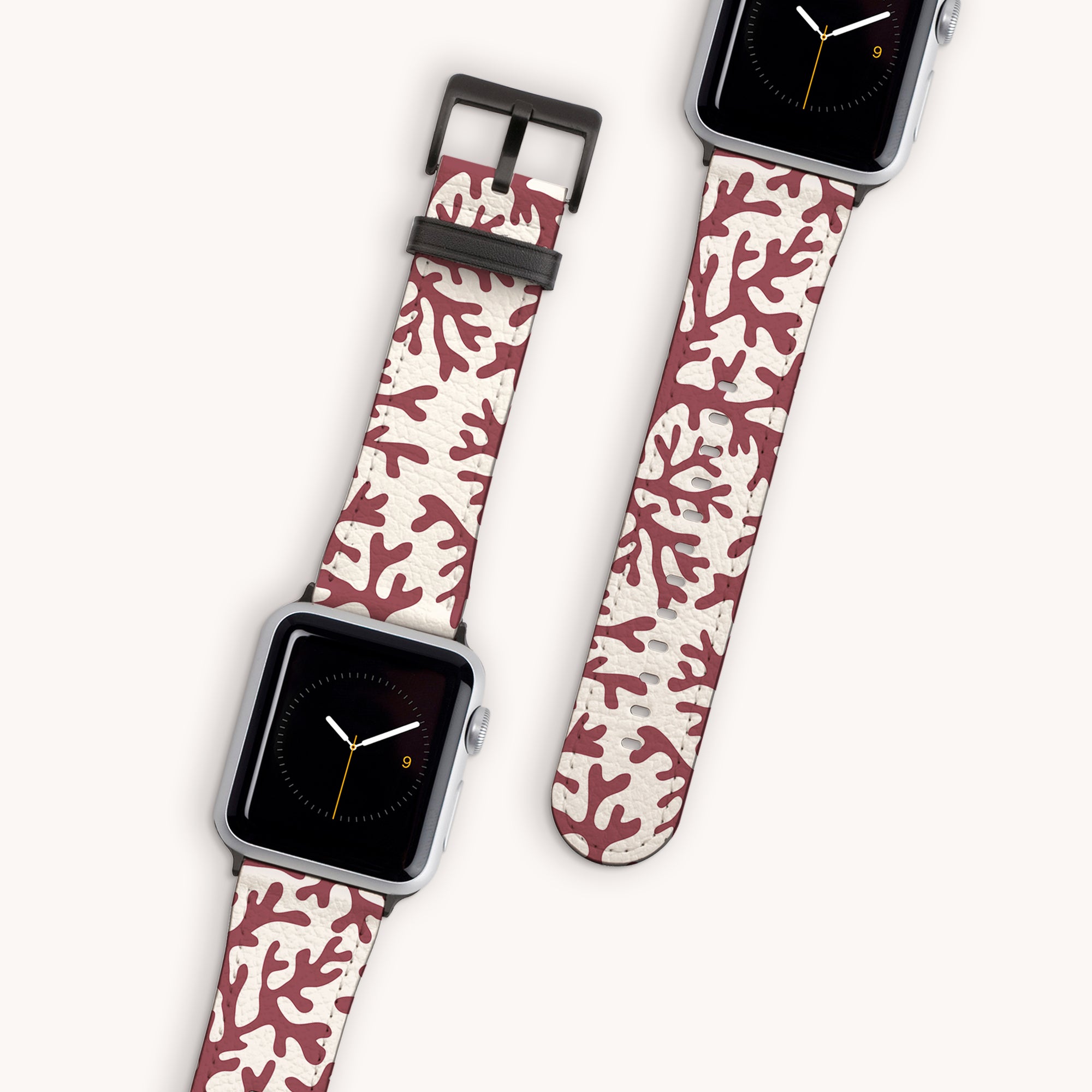 Two smartwatches with silver cases and eco-friendly Brown Coral Vegan Leather straps, featuring a red and white coral design. The Apple Watch Band displays show a simple black clock face with minimalist hands and a number nine marker.