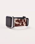 The Brown Cow Vegan Leather Apple Watch Band with a black frame exudes rustic charm against a plain white background.