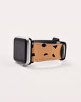 A sleek smartwatch with a black screen showcases the Geo Shapes in Brown Vegan Leather Apple Watch Band, featuring abstract black geometric designs on beige vegan leather, set against a minimalist white background.