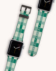 Two Apple watches come with Green Watercolour Checker bands made from vegan leather, ideal for eco-conscious art lovers. The analog displays sit on sleek black backgrounds, and adjustable bands emphasize both intricate design and functionality.