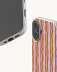 Two Lilac Caramel Wave Eco-Friendly Biodegradable Phone Cases with a textured, speckled finish, featuring a wavy vertical stripe pattern in lilac and caramel.
