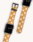 Two smartwatches feature the Star Terracota Check Vegan Leather Apple Watch Band with a floral checkered design in tan and orange, adorned with small white flowers. One displays a minimalist black clock face. Both showcase their eco-conscious style against a plain backdrop.