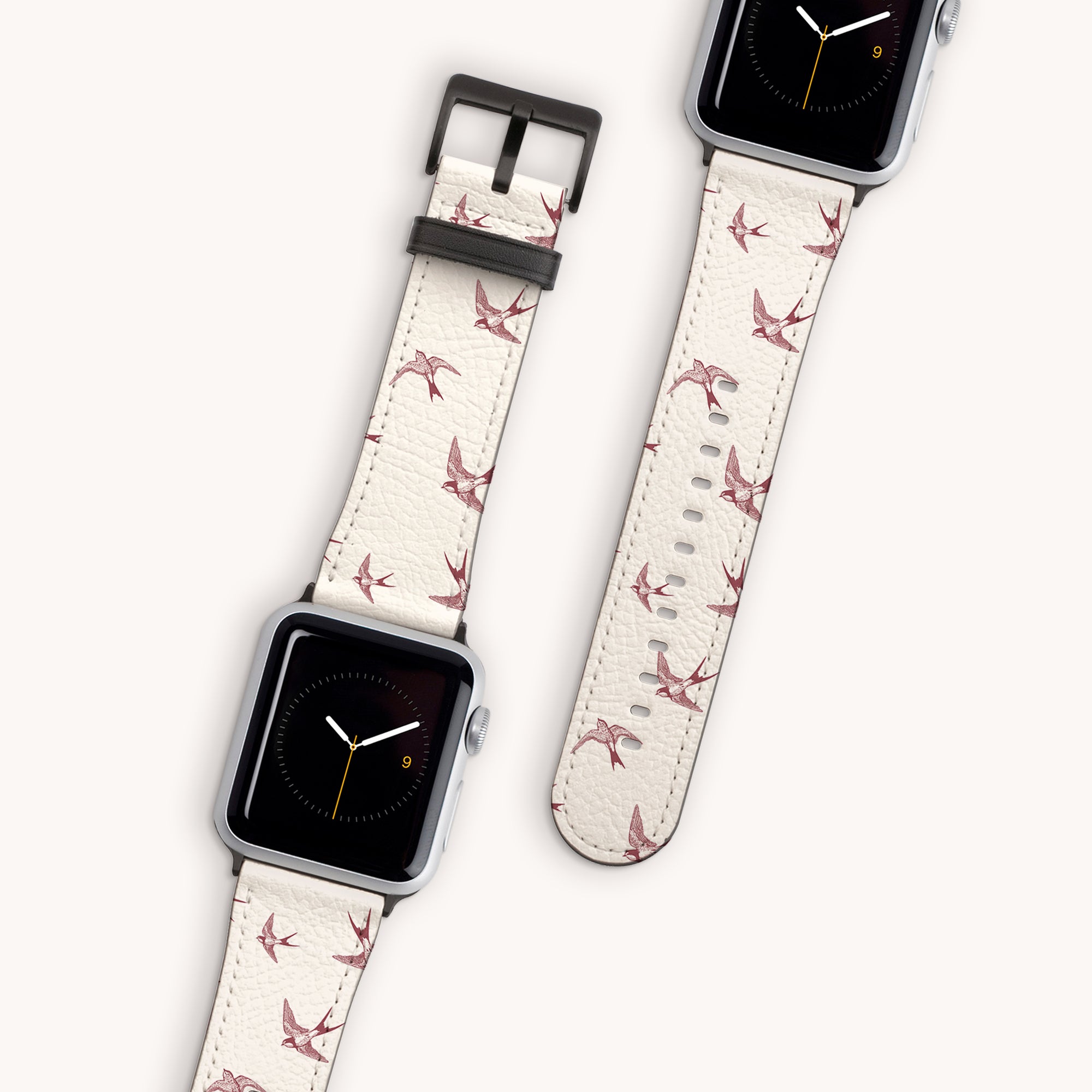 The Swallows Vegan Leather Apple Watch Band features a cream bird-themed strap and minimalist clock face with orange and yellow hands. This eco-friendly accessory promises style and sustainability using vegan leather on a light background.