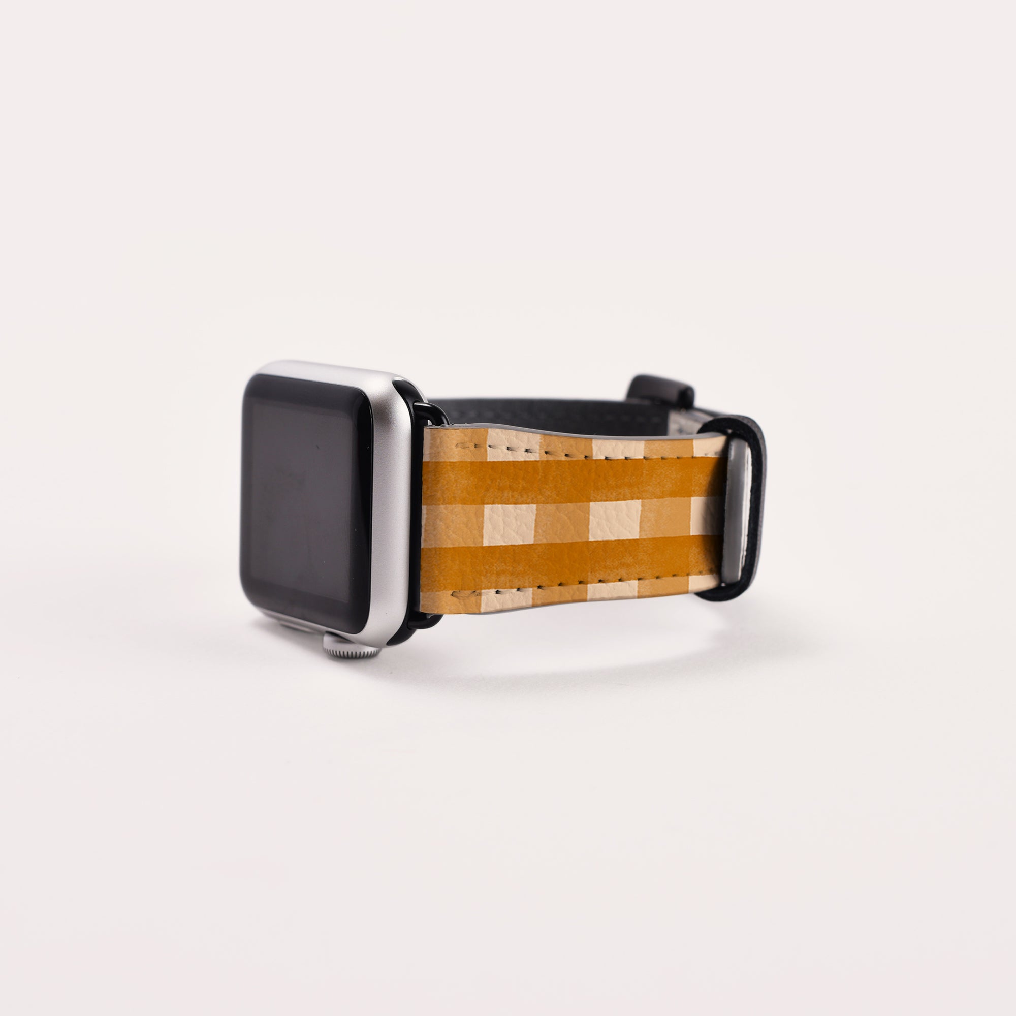 The Terracotta Gingham Vegan Leather Apple Watch Band features a stylish black screen against a minimalist white backdrop.