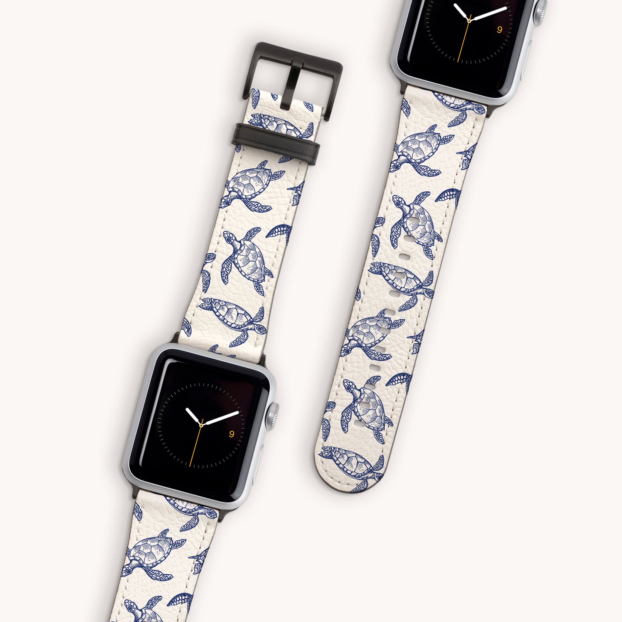 Two smartwatches feature Turtles Vegan Leather Apple Watch Bands with blue sea turtle designs on beige, displaying different times against a white background. This eco-friendly accessory adds oceanic charm to any outfit.