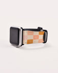 The Pink Checker Vegan Leather Apple Watch Band, featuring colorful shades of pink, orange, and beige, is displayed on a plain white background with the watch face black and turned off.