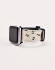 A smartwatch with a silver face features the Xo Xo Vegan Leather Apple Watch Band in beige, adorned with black "XO" symbols and black hardware. This eco-conscious band is elegantly angled against a plain white background.