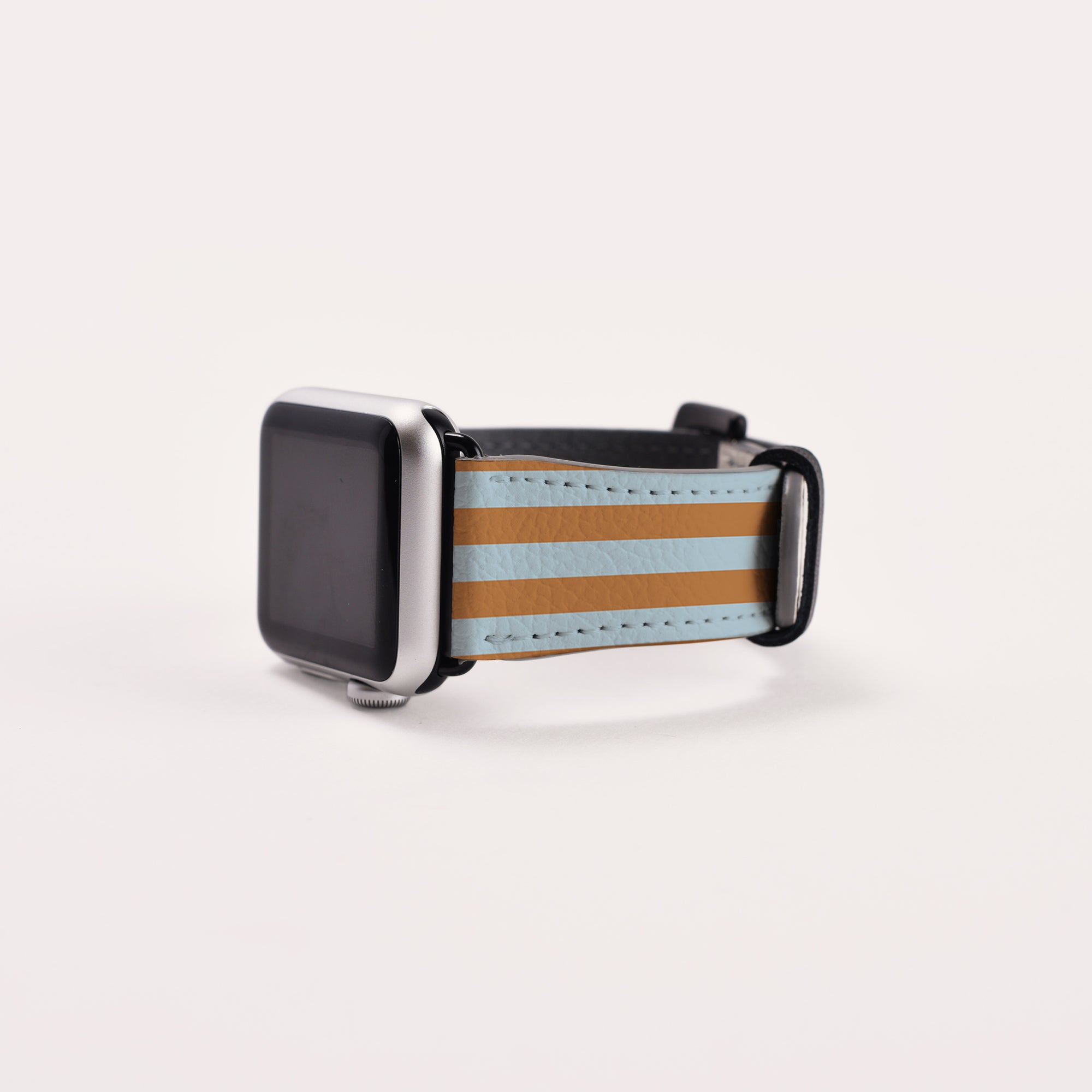A Brown and Blue Stripes Vegan Leather Apple Watch Band exudes timeless elegance. Suitable for Series 1 to 10, this silver-framed watch features a blank screen against a plain white background.