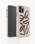 The Brown Bow Ribbon Eco-Friendly Phone Case in speckled beige features a red abstract ribbon design with a green accent near the bottom, shown against a plain white background.