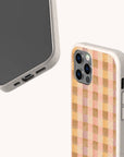 Two smartphones in Pink Watercolour Gingham Eco-Friendly Phone Cases made from compostable materials: one displays the screen and ports, while the other shows off the distinctive pink watercolour gingham pattern on its back.
