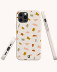 The Mini Confetti Eco-Friendly Phone Case, made from compostable materials, features a terrazzo pattern in green, yellow, orange, and pink on cream. Shown from back, side, and angle. Compatible with iPhone and Samsung Galaxy devices.