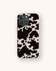 A Cow Print Eco-Friendly Phone Case is displayed on a smartphone against a plain, light background, showcasing its black and white design. The case offers compatibility with both iPhone and Samsung models, emphasizing its stylish and sustainable features.