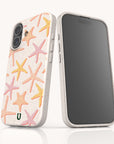 Two smartphones fitted with the Starfish Eco-Friendly Biodegradable Phone Case in white, featuring a pastel starfish pattern on the back. One phone highlights the case’s charming design, while the other shows its front screen. Both stand upright on a light background, emphasizing the stylish yet environmentally conscious construction of these phone cases.