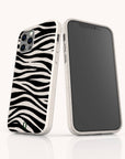 Two Zebra Eco-Friendly Phone Cases in bold black zebra stripe patterns and white finish are shown—one displaying the back, the other the front. Each case features a small green leaf logo at the bottom, emphasizing its eco-friendly design. The background is plain white.
