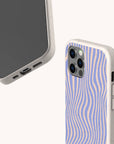 The Blue Distort Lines Eco-Friendly Phone Case, made from biodegradable materials, features a textured beige frame, wavy blue and tan design, fits iPhone & Samsung Galaxy, and is shown front and back on a light background.