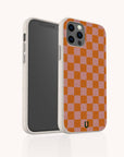 The Orange Checker Eco-Friendly Phone Case features a red and pink checkerboard design, compostable materials, a textured off-white edge, and a small black logo at the bottom center. Shown from front and back angles.