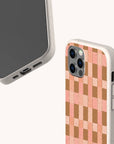 Two smartphones feature the Pink and Brown Watercolour Checker Eco-Friendly Phone Case—one shows the front screen, while the other displays its compostable beige speckled back with a unique pink and brown checkerboard pattern.