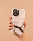 A hand holding the Beige Abstract Eco-Friendly Phone Case—a minimalist phone case with a beige abstract pattern—set against a matching beige background.