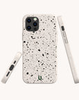 The Black Splatter Eco-Friendly Phone Case, shown from back, side, and bottom angles, highlights its white compostable material with black splatter design, camera cutout, side buttons, and charging port—compatible with iPhone and Samsung models.