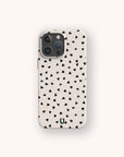 The Black Hearts Eco-Friendly Phone Case is white with scattered black hearts, has camera lens openings at the top left, and a small green "U" logo at the bottom center.