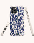 The Ocean Waves Eco-Friendly Phone Case, featuring a blue wavy stripe pattern on a white background, is displayed from three angles—back, side, and bottom. This biodegradable phone case offers precise cutouts for the camera, buttons, and charging port.