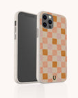 The Pink Watercolour Checker Eco-Friendly Phone Case features a pink and orange checkerboard pattern, a textured, speckled off-white border, a zero-waste design, and fits both iPhone and Samsung Galaxy models.