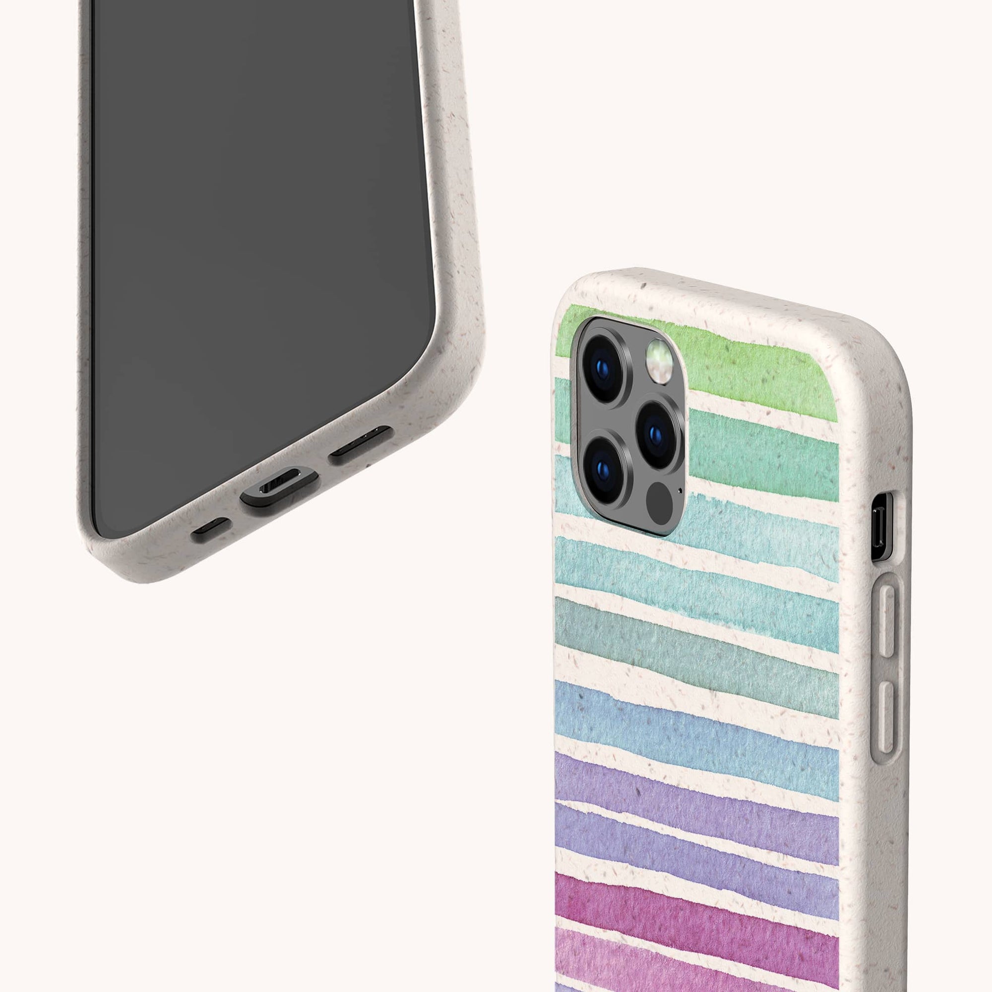 The Winter Rainbow Eco-Friendly Phone Case in speckled beige features pastel horizontal stripes in green, blue, purple, and pink. The smartphone is displayed from the back and bottom angles against a plain light background.