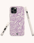 Three Purple Marble Swirl Eco-Friendly Phone Cases with a beige base and wavy, abstract lavender patterns are displayed from different angles against a plain background, offering a stylish take on the eco-friendly phone case trend.