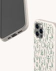 Two smartphones in light cases: one displays the Green Wild Flowers Eco-Friendly Phone Case with a minimalist green botanical design made from biodegradable materials; both cases fit iPhone and Samsung Galaxy models.