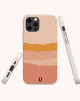 The Valleys Eco-Friendly Phone Case features a compostable design with horizontal pink, peach, and orange stripes. Compatible with iPhone and Samsung Galaxy, it's shown from the back, side, and bottom on a light background.