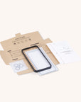 The Eco Glass Screen and Camera Lens Protector, featuring a black frame and adhesive rings, is made from recycled tempered glass. It’s packaged in a cardboard box labeled "Eco-Glass" with installation tools and an instruction booklet.