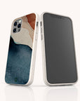 Two smartphones in white Watercolour Landscape Eco-Friendly Phone Cases are shown; one displays the screen, while the other shows the back with blue, beige, and brown abstract watercolor-like shapes made from sustainable materials.