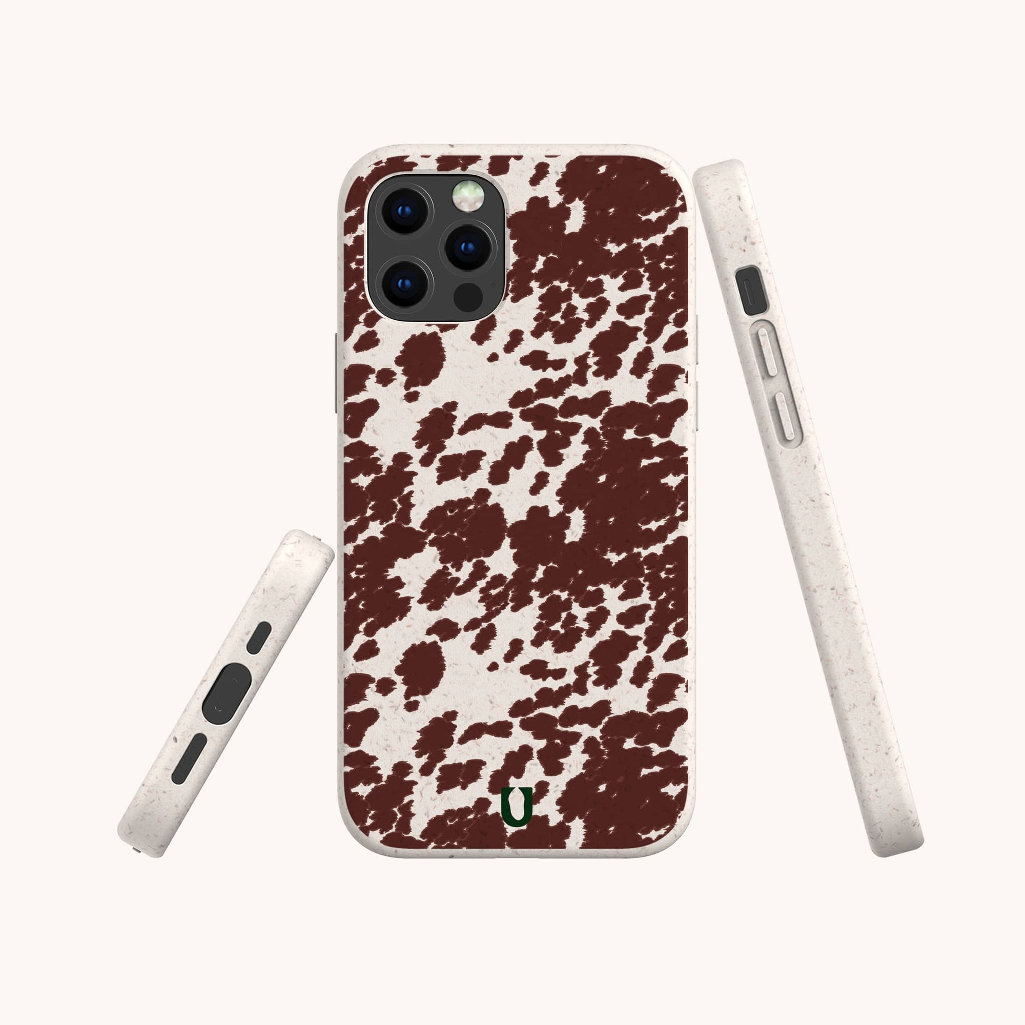 Three views of the Brown Cow Print Eco-Friendly Phone Case, featuring a green horseshoe logo, white sides with accessible buttons and ports, and compatible with iPhone and Samsung Galaxy devices.