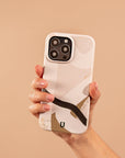 A hand holds the Beige Abstract Eco-Friendly Phone Case, made from biodegradable materials and compatible with iPhone and Samsung Galaxy, against a solid beige background.