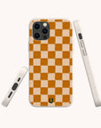 The Brown Checker Eco-Friendly Phone Case features an orange and beige checkerboard pattern, rounded edges, and a small black horseshoe logo near the bottom, shown from the back, side, and bottom angles.