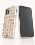 The Pink Flower Checker Eco-Friendly Phone Case features a pink-and-white checkerboard with green floral design, shown on a smartphone. Another device displays the blank front. Compatible with iPhone and Samsung models.
