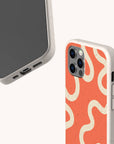 Two smartphones in beige speckled cases, one showcasing the Orange Swirl Eco-Friendly Biodegradable Phone Case with a playful wavy cream and orange pattern, and the other displaying the phone screen and charging port, set against a light background. These eco-friendly biodegradable phone cases offer stylish sustainability for your everyday tech accessories.
