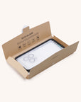 Eco-friendly packaging for the Eco Glass Screen and Camera Lens Protector, partially open to reveal its contents. The simple design shows instructions on the inside flap, emphasizing its sustainable features made from recycled tempered glass.