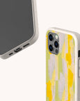 Two Lime Sorbet Eco-Friendly Phone Cases with biodegradable, speckled natural textures: one showcases a yellow and green abstract pattern on the back, while the other displays the phone’s front screen and bottom charging port. Both cases are compatible with iPhone and Samsung Galaxy devices.