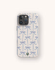 A phone with a Blue Bow Ribbons Eco-Friendly Biodegradable Phone Case, showcasing a repeating pattern of blue bows on a light, subtly speckled background. A small green U logo is placed at the bottom center.