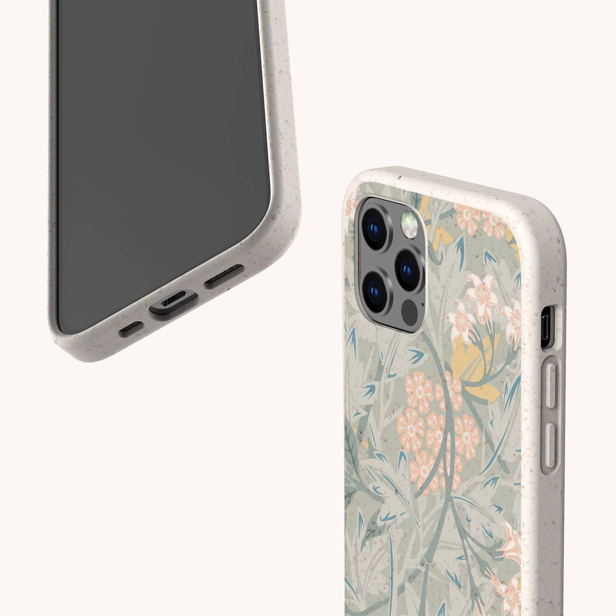 Two smartphones with Jasmine Eco-Friendly Phone Cases in light colors: one facedown showing floral motifs, the other faceup displaying the screen as well as the case’s accessible ports and buttons.