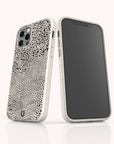Two smartphones with white cases are shown. One phone features the Mini Strokes Eco-Friendly Biodegradable Phone Case, designed with an abstract black dot and line pattern, while the other phone displays a blank, black screen. Both phones are standing upright on a white surface.