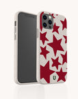 Two smartphones in Burgundy Stars Eco-Friendly Biodegradable Phone Cases, featuring red star patterns. One phone displays the screen facing forward, while the other is angled to show the back and side of the sustainable case.