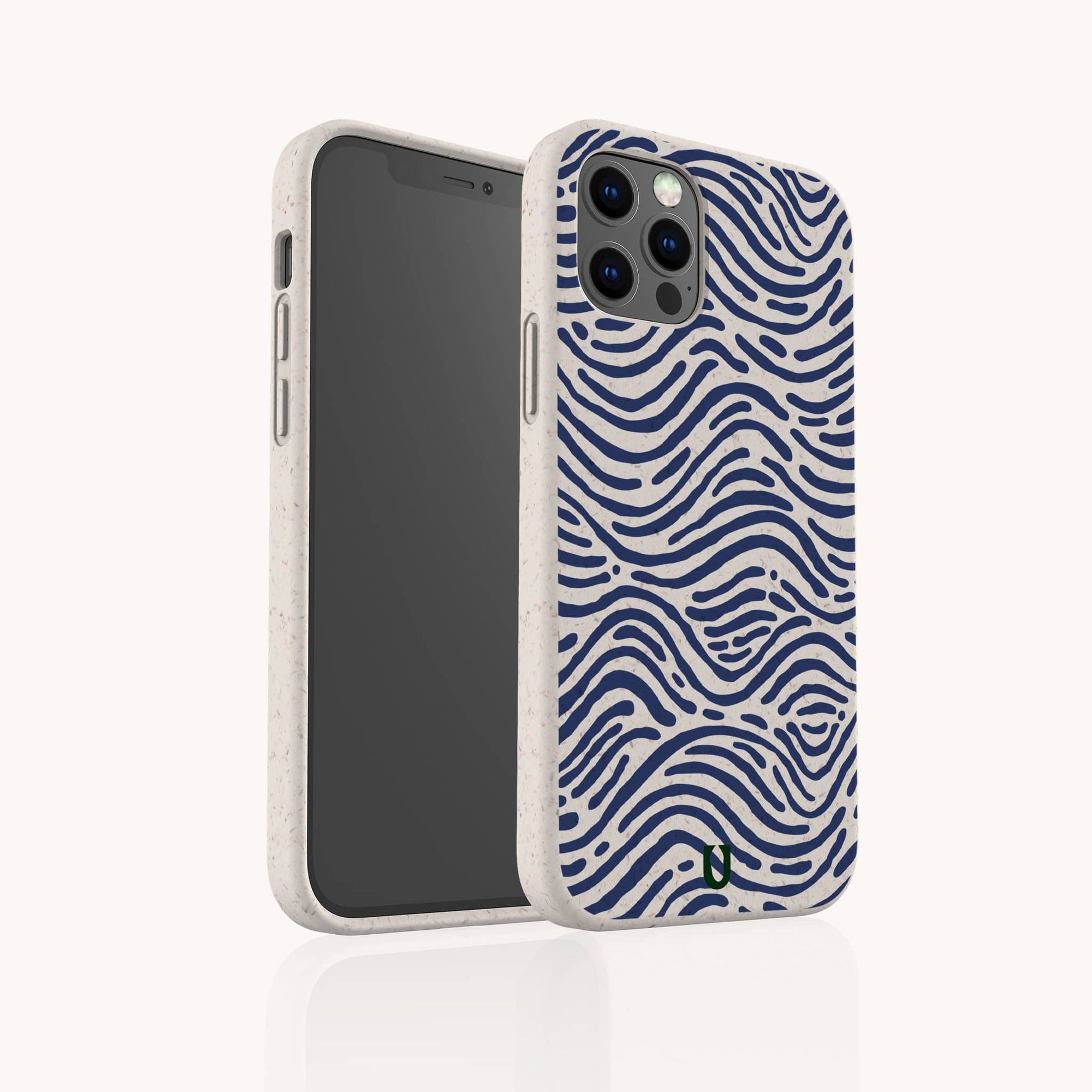 The Ocean Waves Eco-Friendly Phone Case, shown in beige with a wavy navy blue ocean-inspired pattern, stands upright to display its biodegradable back design and the screen facing left.