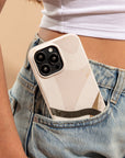 A person in a white crop top and blue jeans has a Beige Abstract Eco-Friendly Phone Case, made from biodegradable materials and compatible with iPhone and Samsung Galaxy, sticking out of their front jeans pocket.