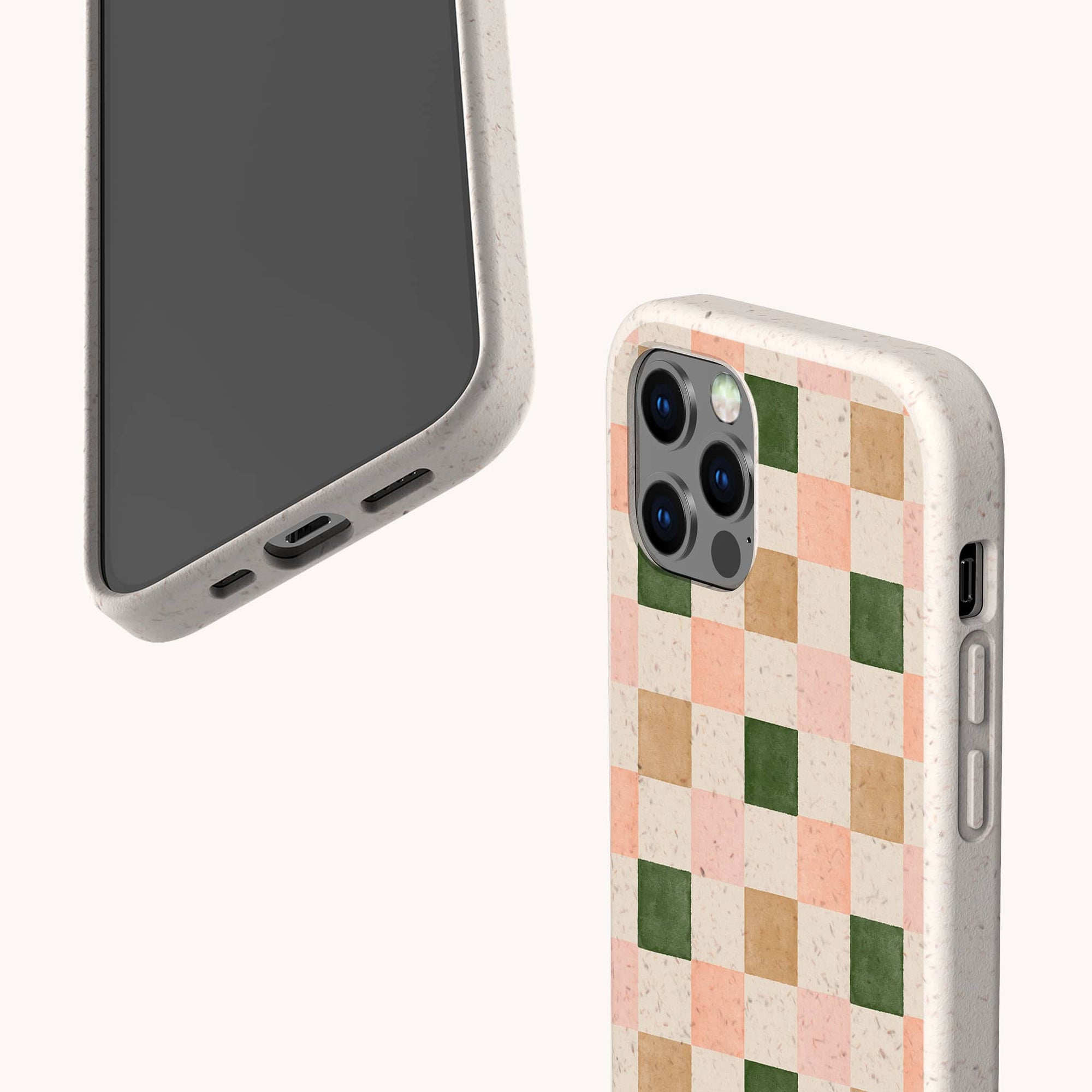 Two smartphones in Pink and Green Checker Eco-Friendly Phone Cases—one shows the screen and charging port, the other features a pastel pink, beige, green, and peach checkerboard pattern. Compatible with iPhone and Samsung Galaxy.