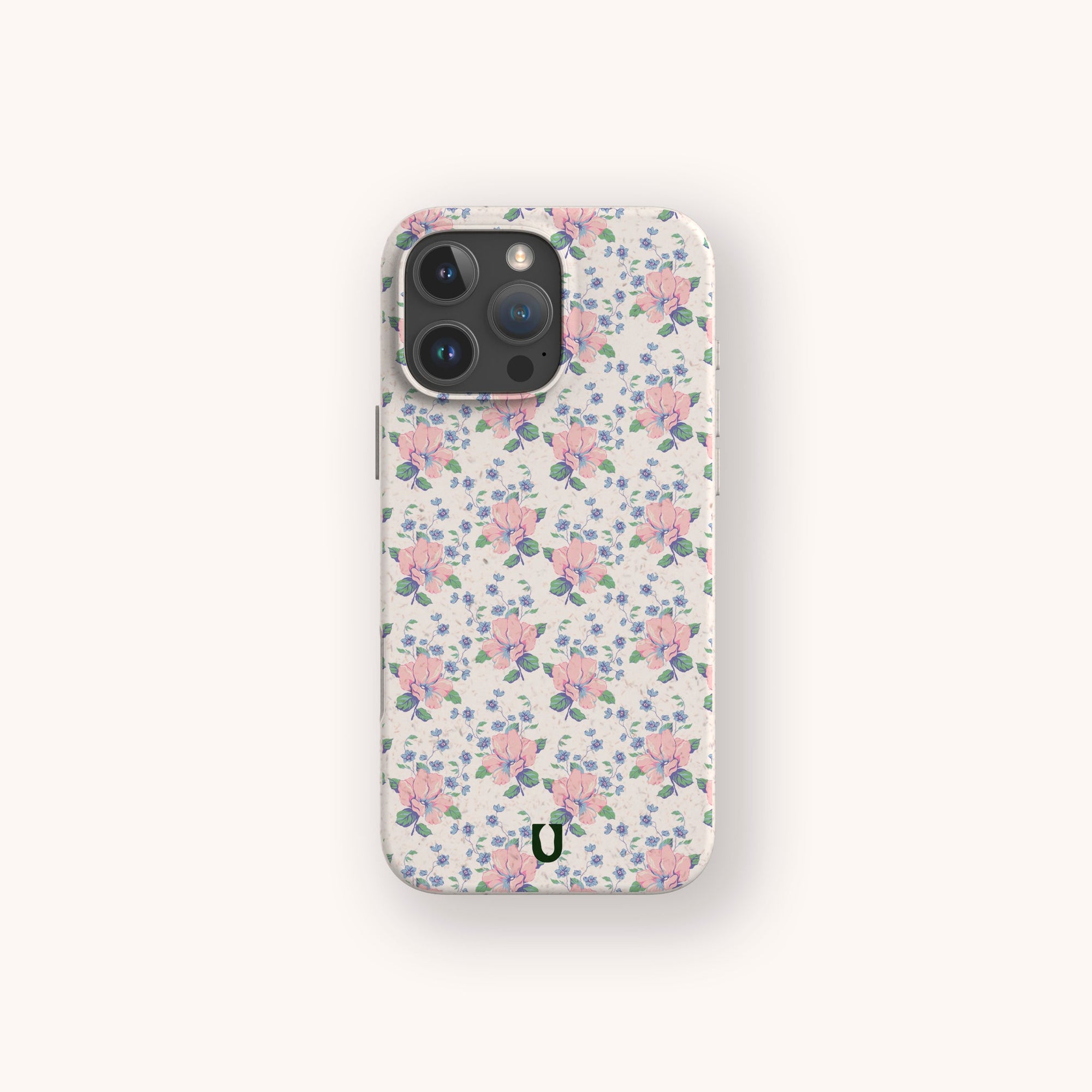 The Pink Coquette Flowers Eco-Friendly Biodegradable Phone Case features a pastel floral pattern with green leaves on a light background and a black horseshoe logo, offering stylish, sustainable protection for your smartphone.