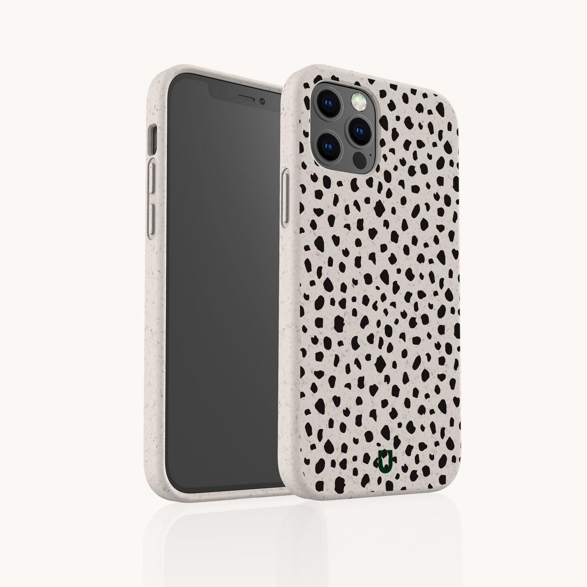 The Dark Spots Eco-Friendly Phone Case, featuring a minimalist beige design with black irregular spots reminiscent of a Dalmatian pattern, is displayed upright beside another case angled to showcase the camera cutout and overall design. This eco-friendly case is compatible with both iPhone and Samsung Galaxy models.