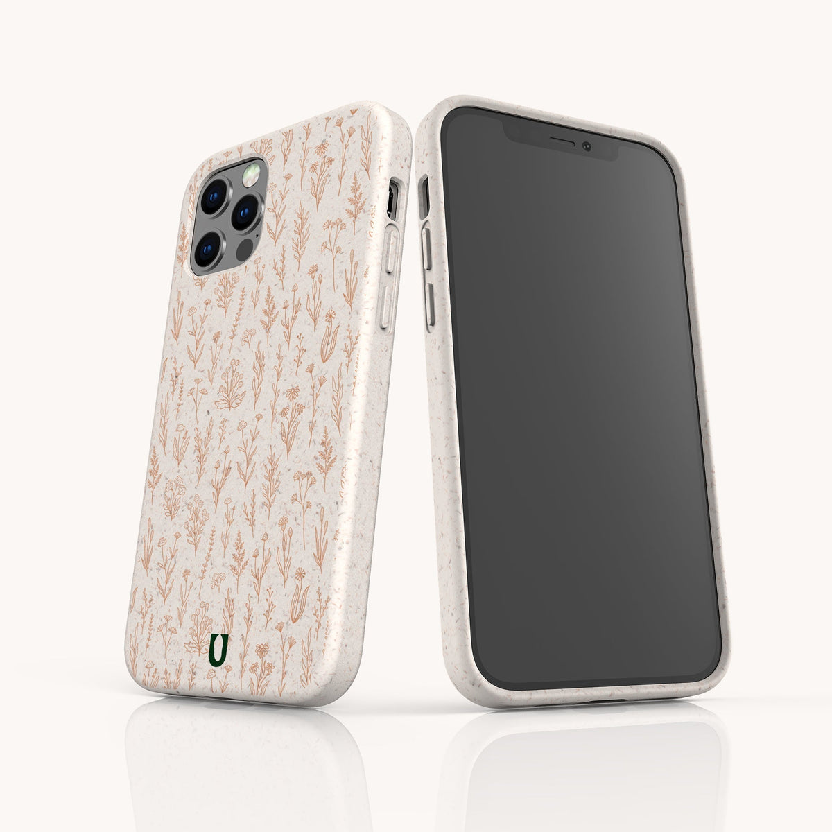 Two smartphones in eco-friendly Pink Wild Flowers phone cases, featuring a delicate floral pattern. One phone showcases the front screen, while the other displays the patterned back with camera lenses and a small green horseshoe logo near the bottom.