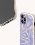 Two smartphones in beige Blue Distort Lines Eco-Friendly Phone Cases; one case displays a back view featuring wavy blue and beige lines, while the other highlights the bottom ports and part of the screen. These stylish, sustainable phone cases are compatible with both iPhone and Samsung models—perfect for anyone seeking eco-conscious protection without compromising versatility.